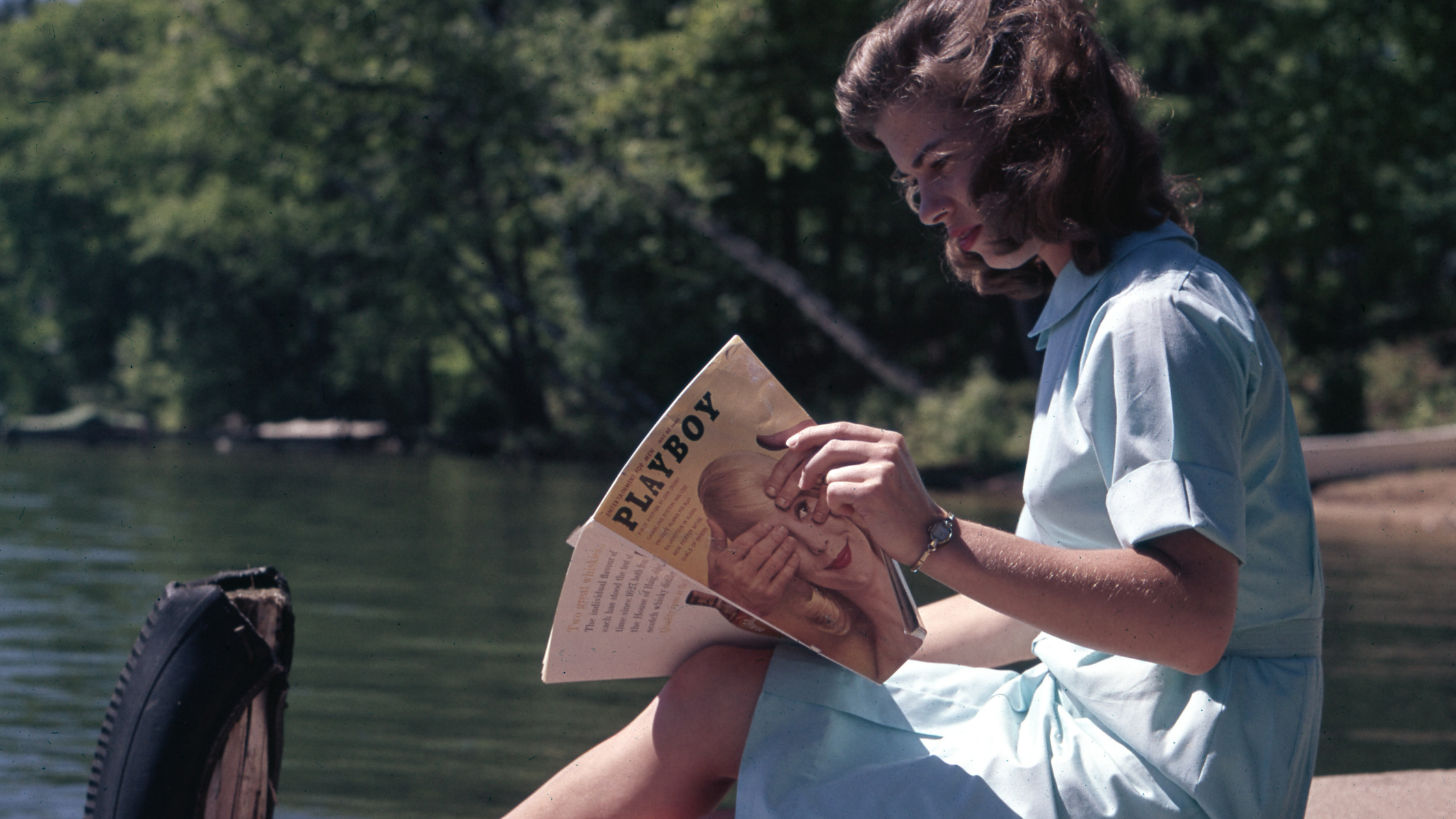 woman reading on the dock of a river